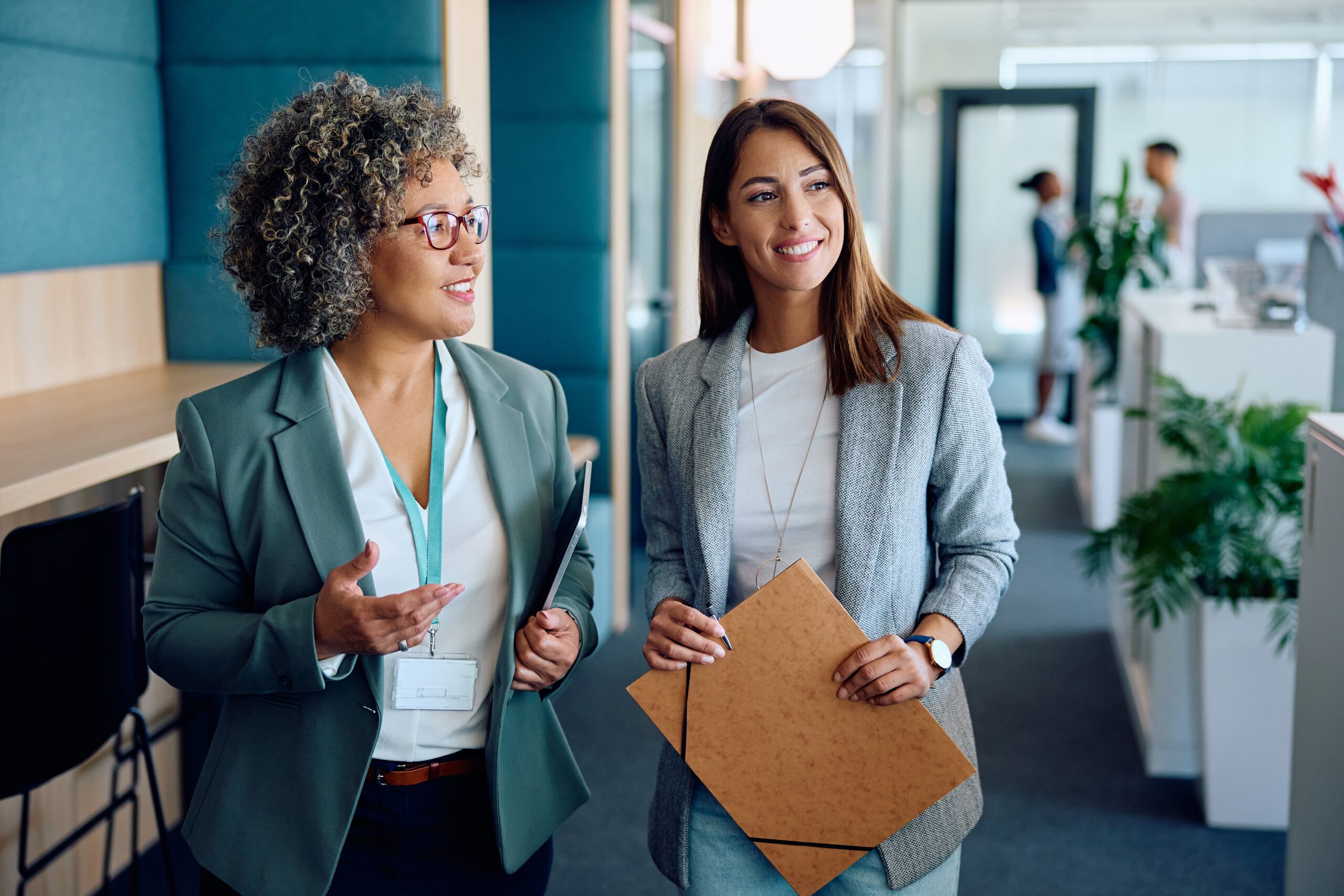 Happy,Mature,Businesswoman,And,Her,Female,Coworker,Communicating,While,Going